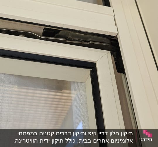 חלון עם מסגרת לבנה ותריס גלילה